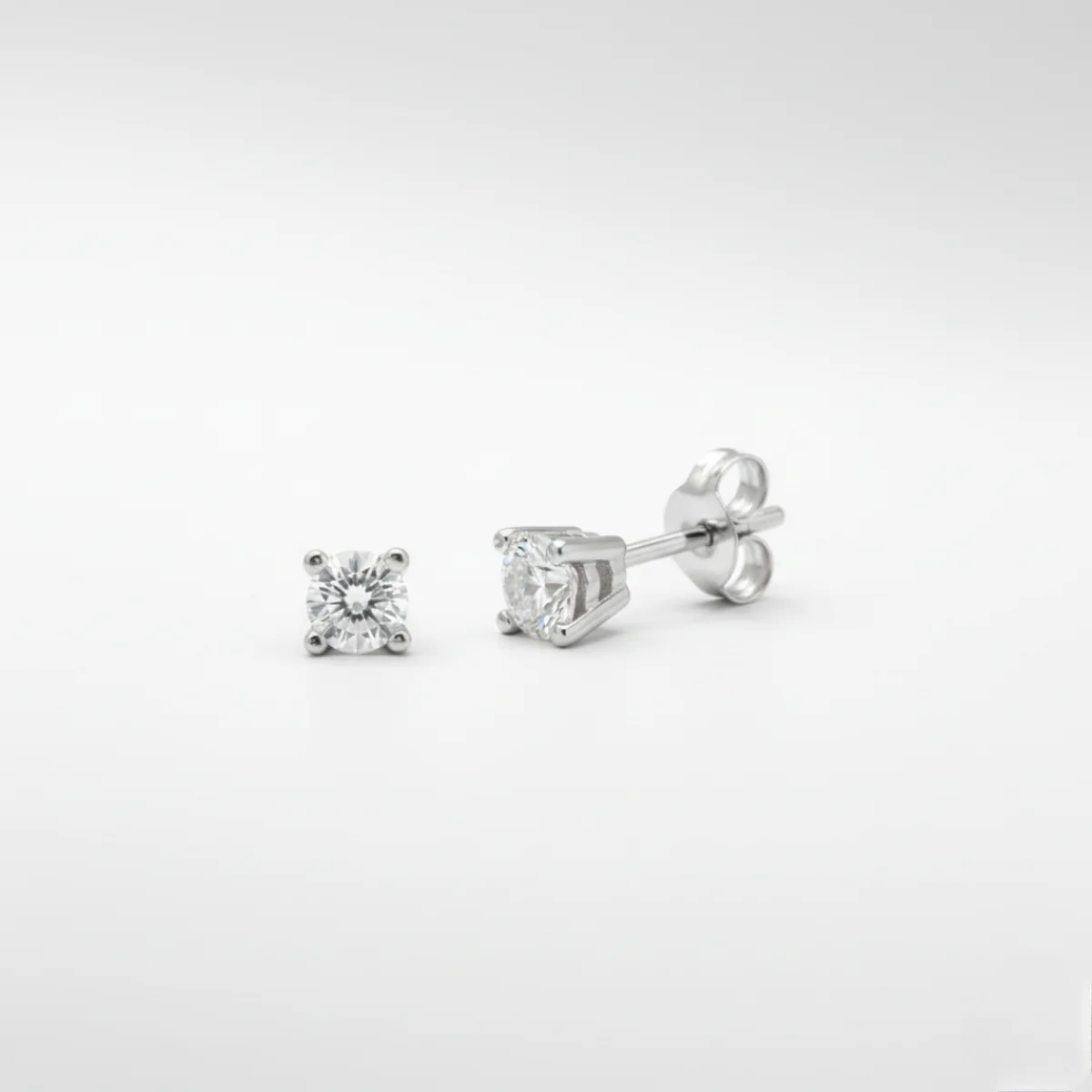 Primer plano de pendientes de diamantes 0.50 ct en oro blanco, engaste de cuatro garras.